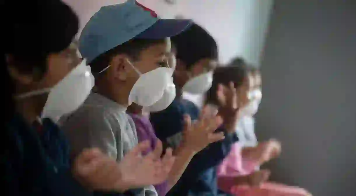 Children wear masks as they sanitise their hands at a preschool in Lenasia, Johannesburg