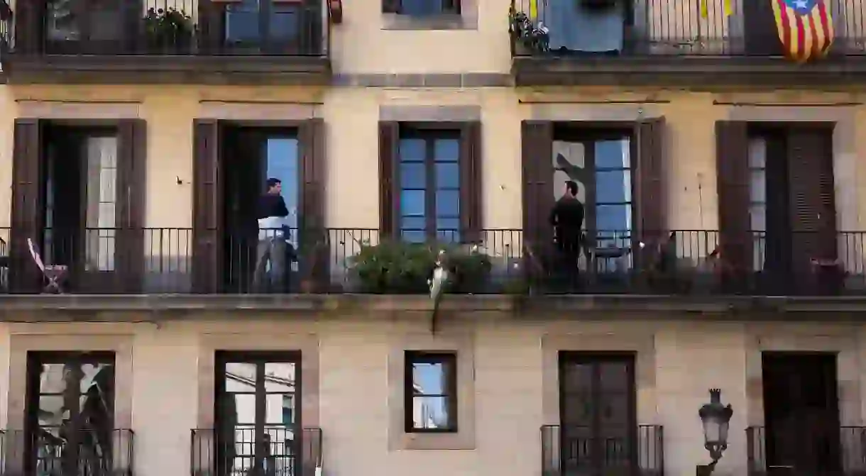 Two neighbours talk from their own balconies during Barcelona’s lockdown