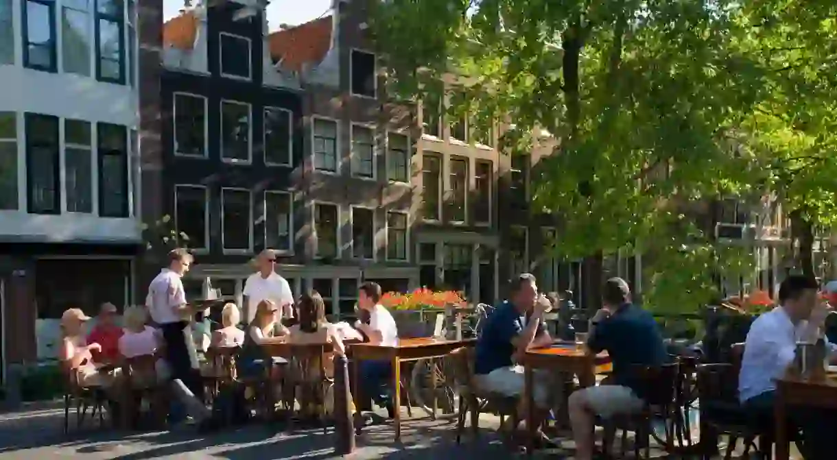 Outdoor dining on the canal bridge in Jordaan, Amsterdam. Now you can enjoy food and drink experiences like a local