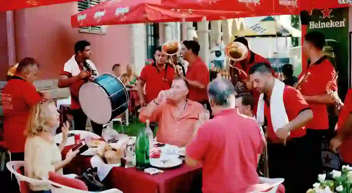 Guests are serenaded by bands while eating at the 2019 Guča Trumpet Festival