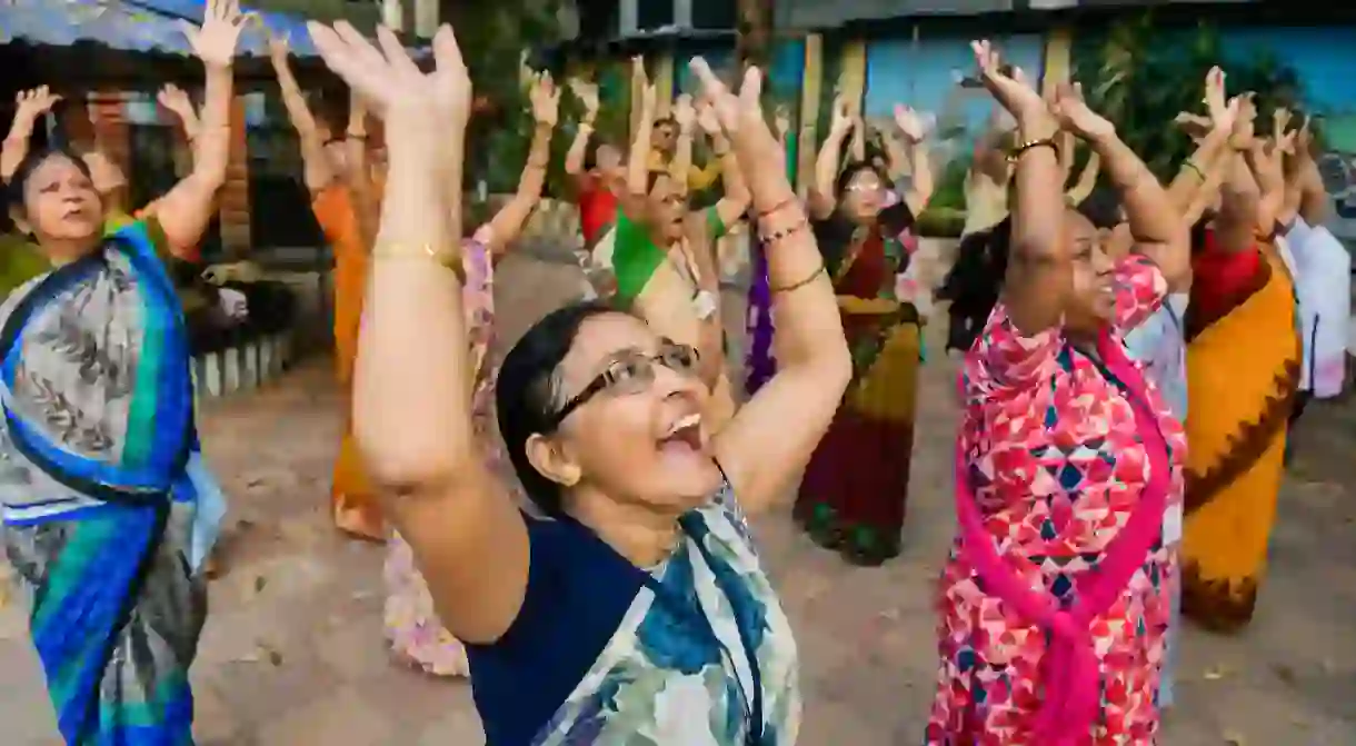 Senior People enjoy laughter yoga session at college square laughing club in kolkata.Laughter yoga helps to increase happiness, but it also strengthens the immune system, reduces pain and lowers stress. It combines simulated laughter exercises with gentle breathing techniques.