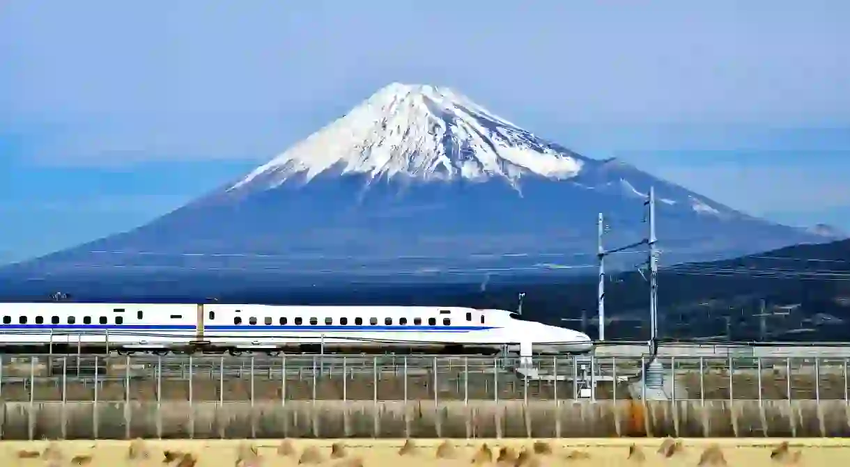 A high-speed bullet train passes below Mount Fuji in Japan