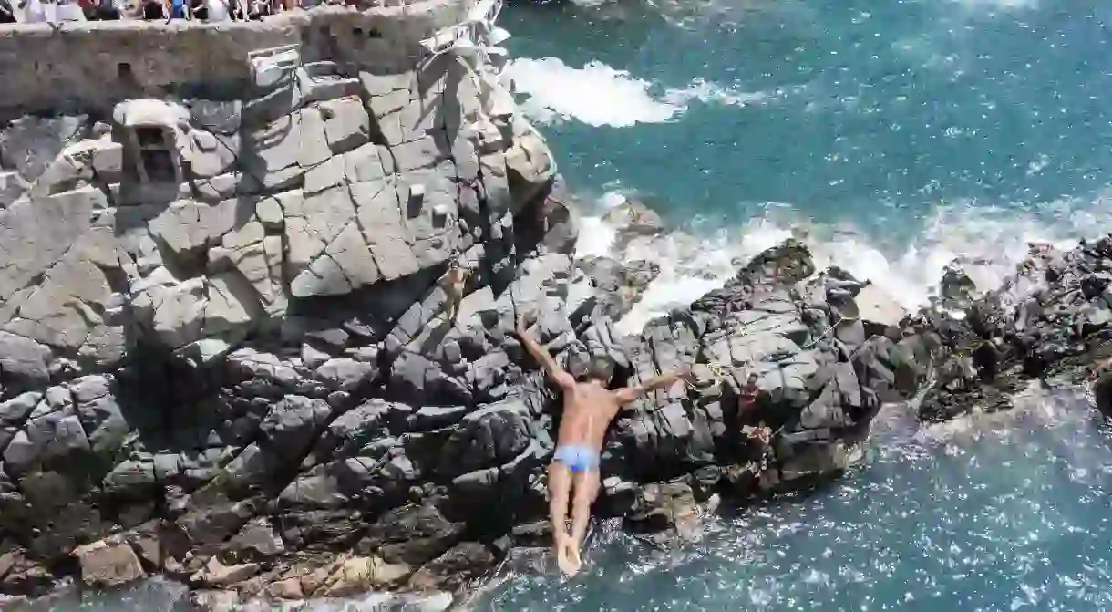 A clavadista, or cliff diver, dives for tourists from the cliff known as La Quebrada in Acapulco