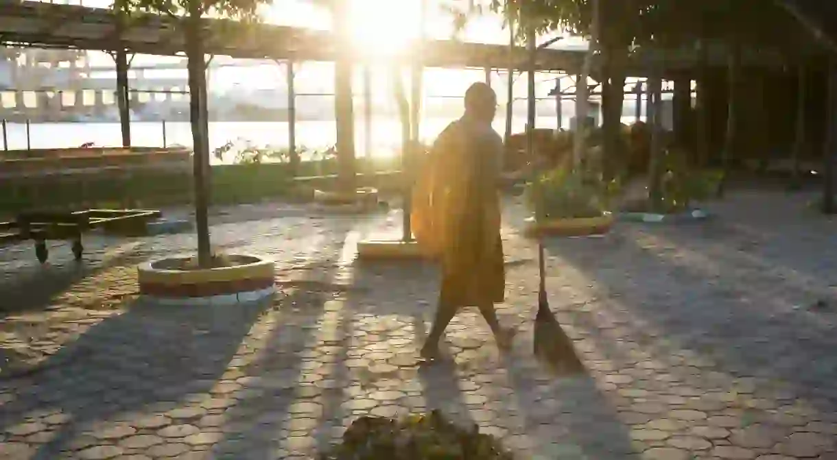 Phra Mahapranom Dhammalangkaro, abbot of Chak Deang Temple, sweeps the temple for leaves at the end of the day