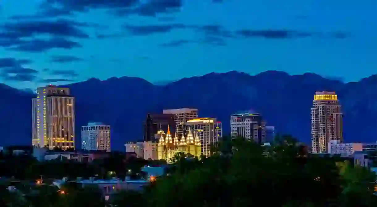 The Salt Lake City skyline by night. The city sits in a valley, with stunning mountain backdrops all around