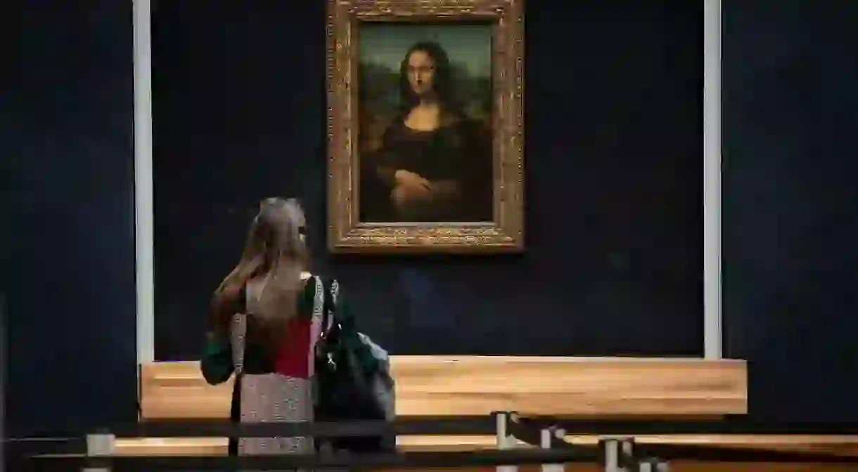 A woman in front of Italian artist Leonardo da Vincis Mona Lisa at the Louvre in Paris