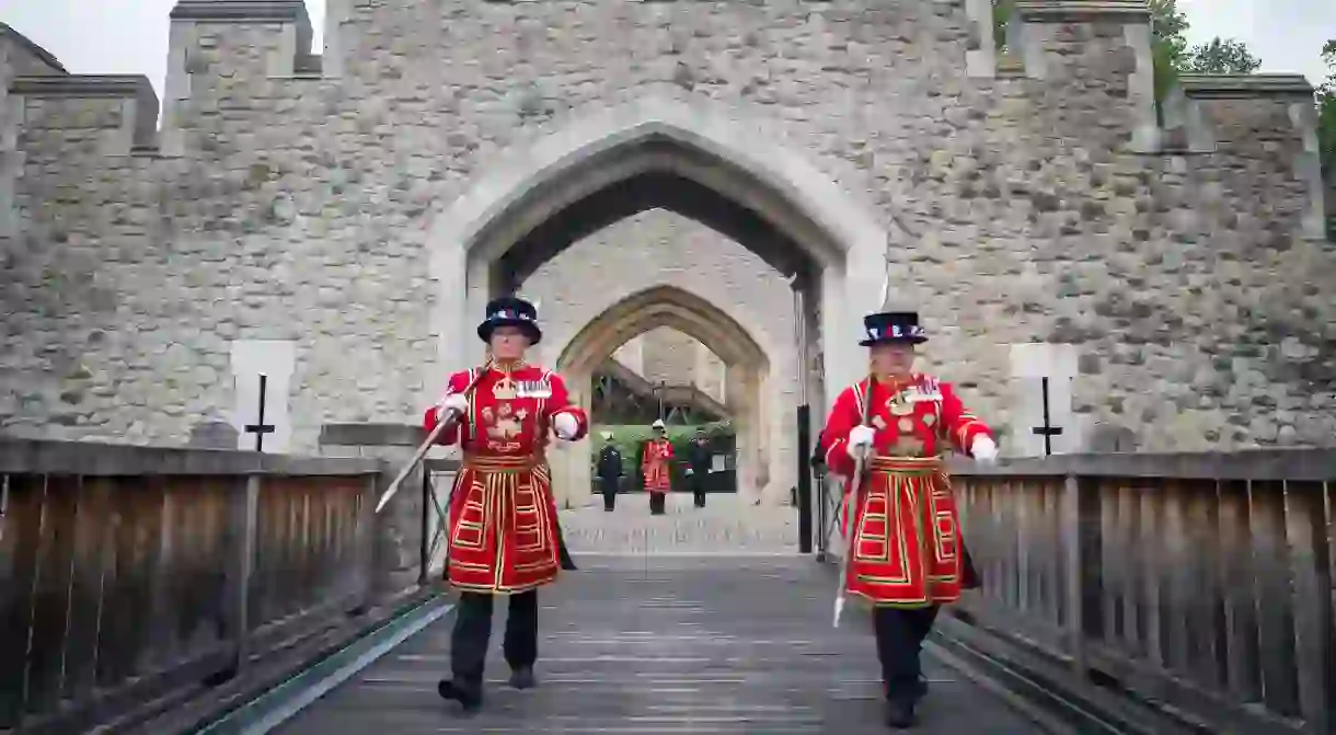 Yeoman Warders, commonly known as Beefeaters, march across the Middle Drawbridge at the Tower of London