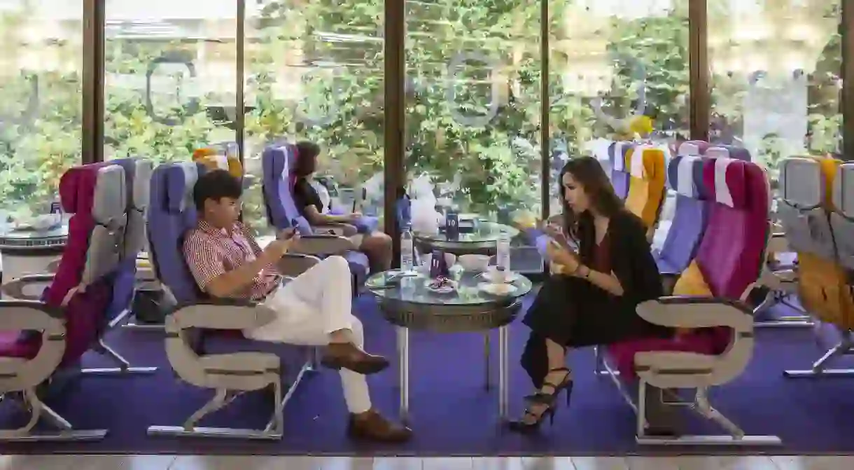 Customers sit on airplane seats as they dine at the Royal Orchid Dining Experience, a Thai Airways International pop-up restaurant