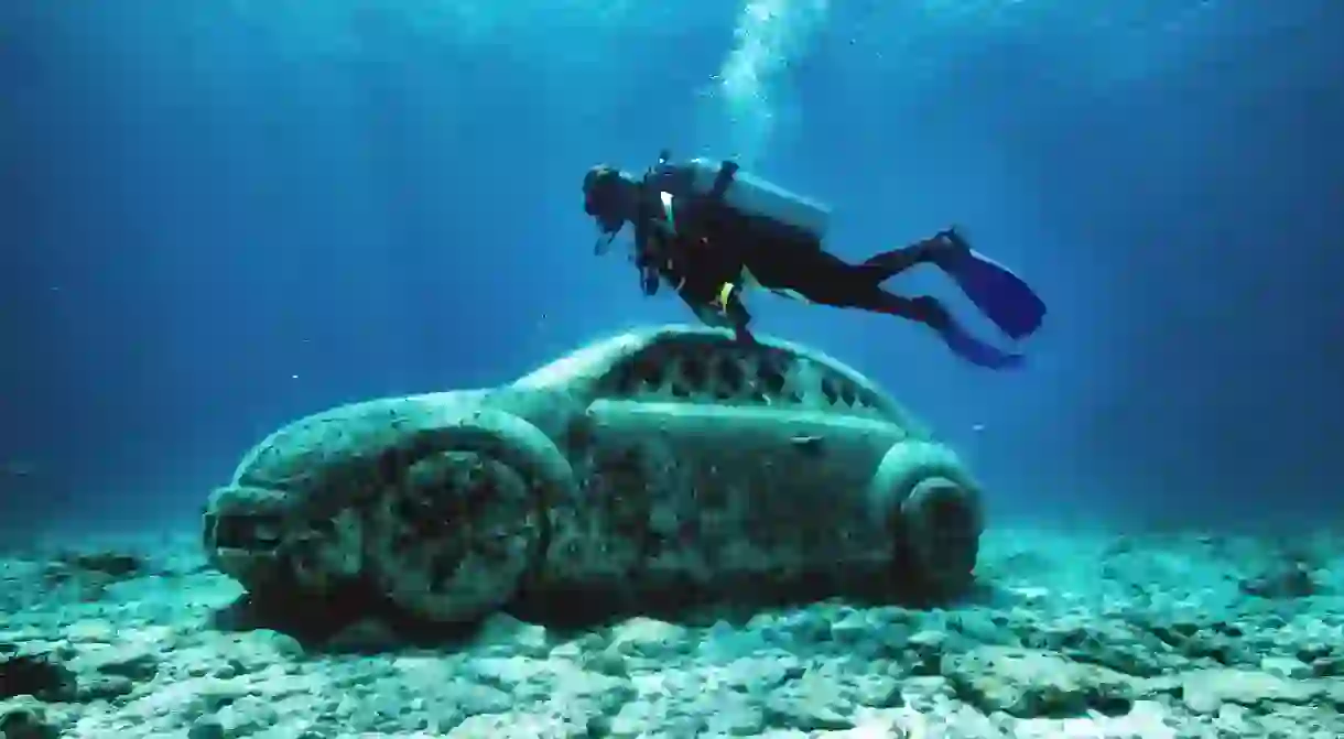 A tourist dives to visit the Underwater Art Museum in Cancun