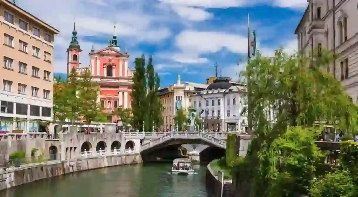 The Ljubljanica River and the Franciscan Church of the Annunciation welcome visitors to Slovenias capital