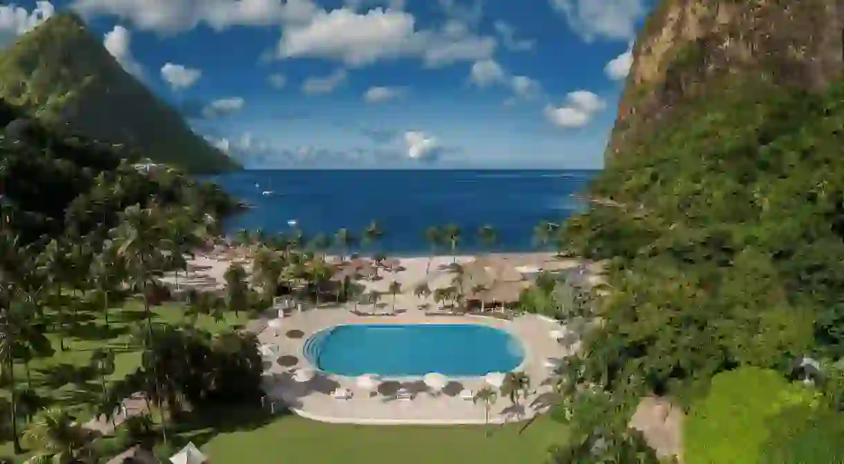 Sugar Beach is framed by a lush bowl of tropical forest and loomed over by the famous Pitons