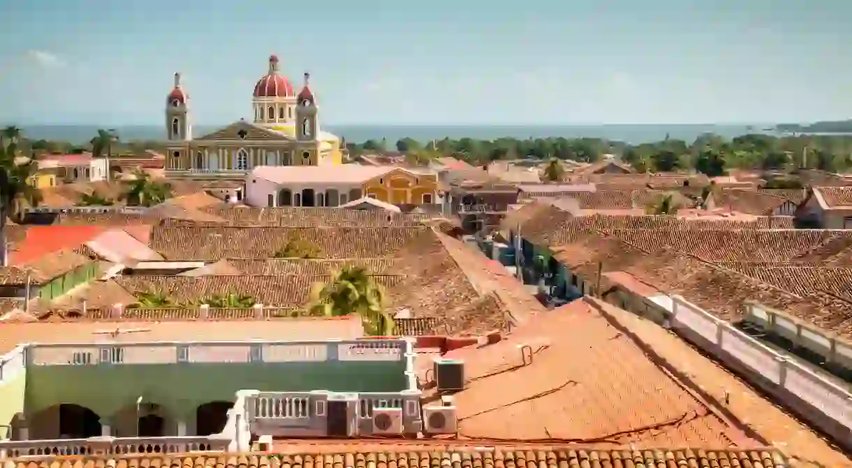 Red-tiled roofs and the mustard-yellow cathedral dominate the view of the historical center of Granada, Nicaragua