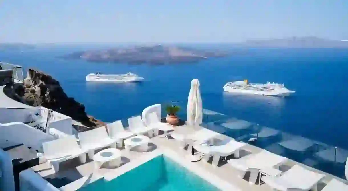 The blazing whitewashed buildings of Athina Luxury Suites on Santorini gaze out onto the azure Aegean