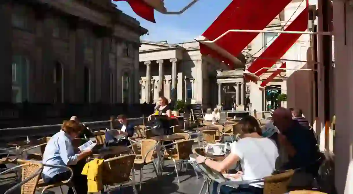 Hipsters get their caffeine fix in a rare moment of Scottish sunshine at Royal Exchange Square, Glasgow