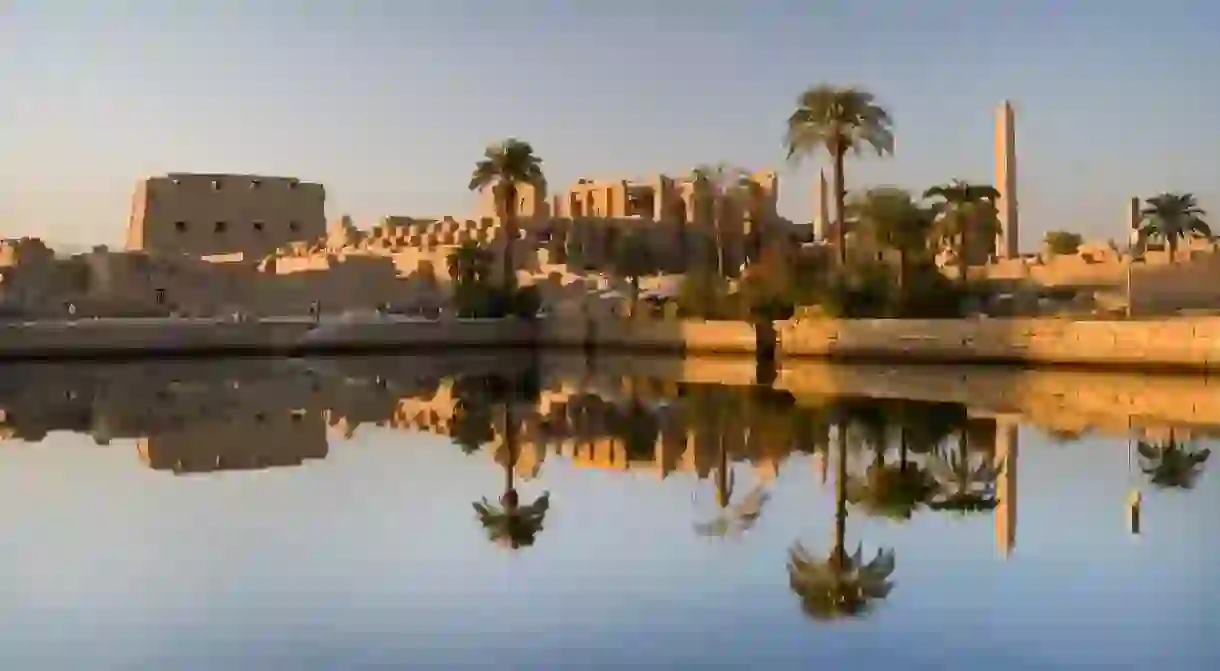 The Temple of Karnak, in Luxor, reflected in the sacred lake at sunset