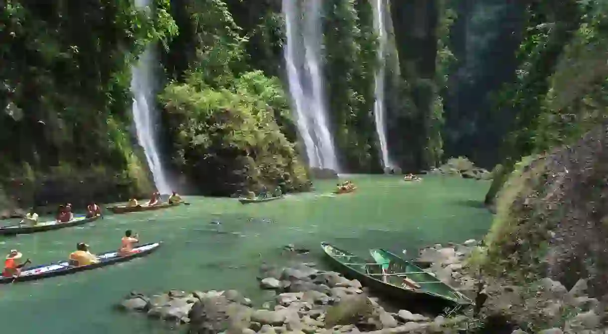 Tourists in boats snap photographs of Pagsanjan Falls on Luzon Island in the Philippines