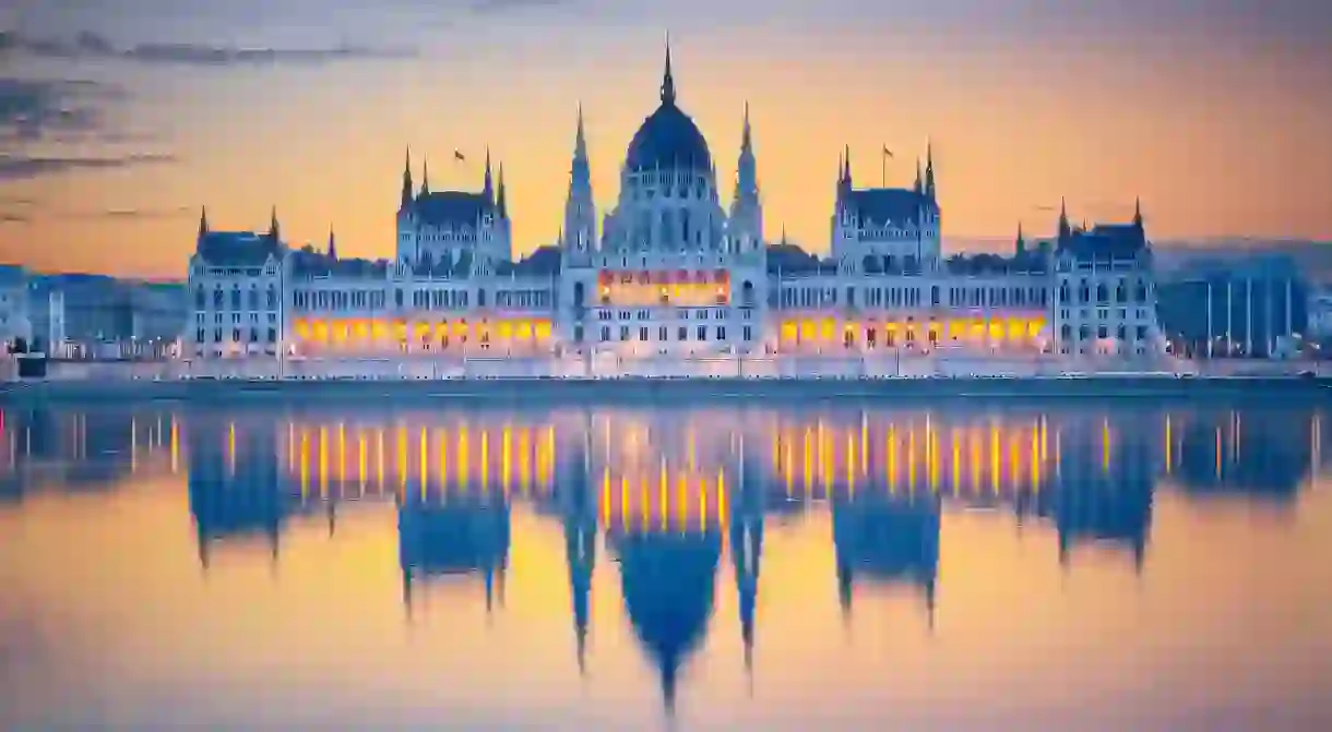 Admire the sun rising over majestic Hungarian parliament building in Budapest.