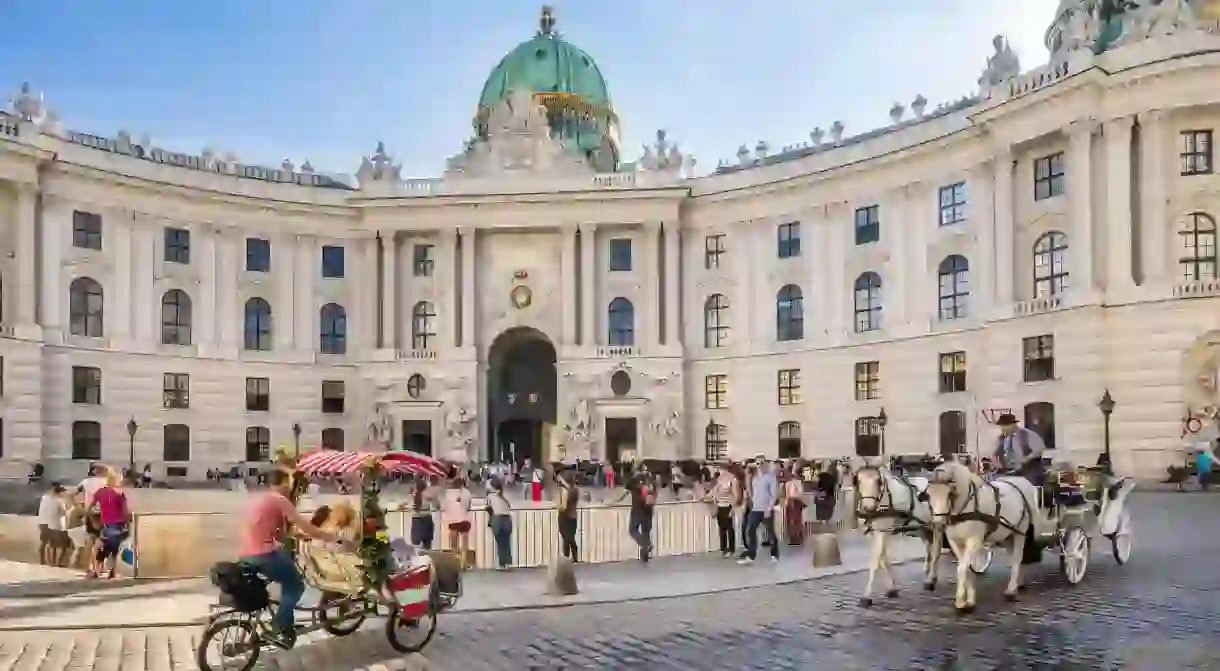 Marvel at The Hofburg palace complex, the former home of Habsburg emperors, from Michaelerplatz