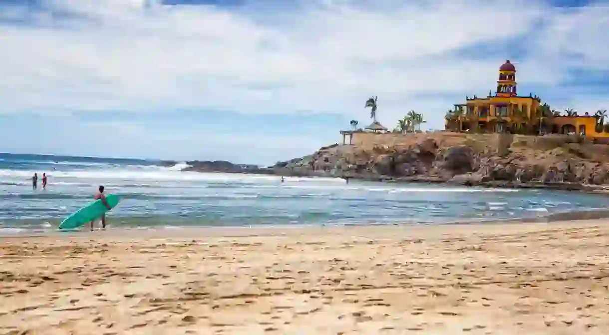 Tourists And Locals Swim And Surf In The Pacific Ocean At Los Cerritos, Todos Santos, Baja Sur, Mexico