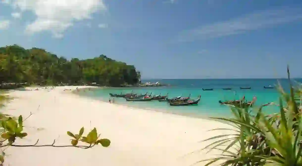 Freedom beach in Phuket Thailand with boats tied up and clear water