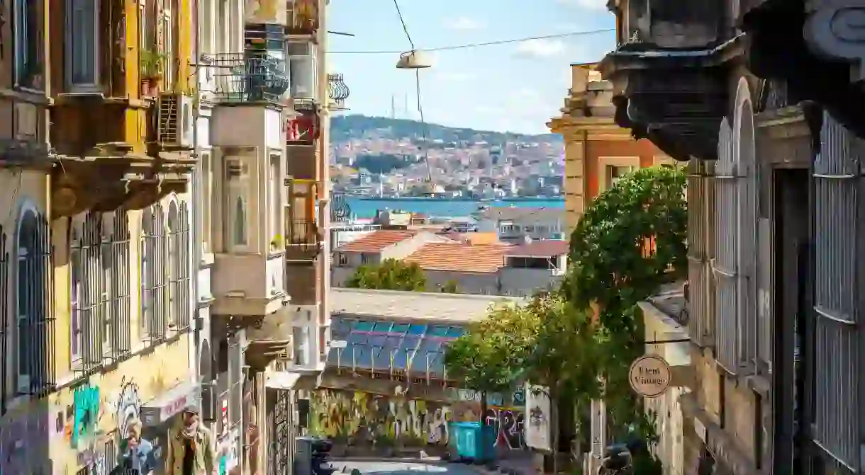 2A4PE59 A couple walks the hilly Galata Karakoy district with the Bosphorus River, Asia and Golden Horn in the distance in Istanbul, Turkey.