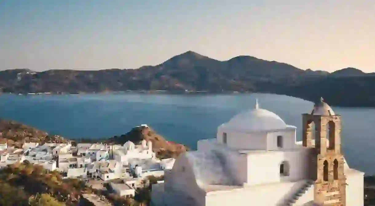 White-washed buildings contrast the blue see in Plaka on Milos, Greece