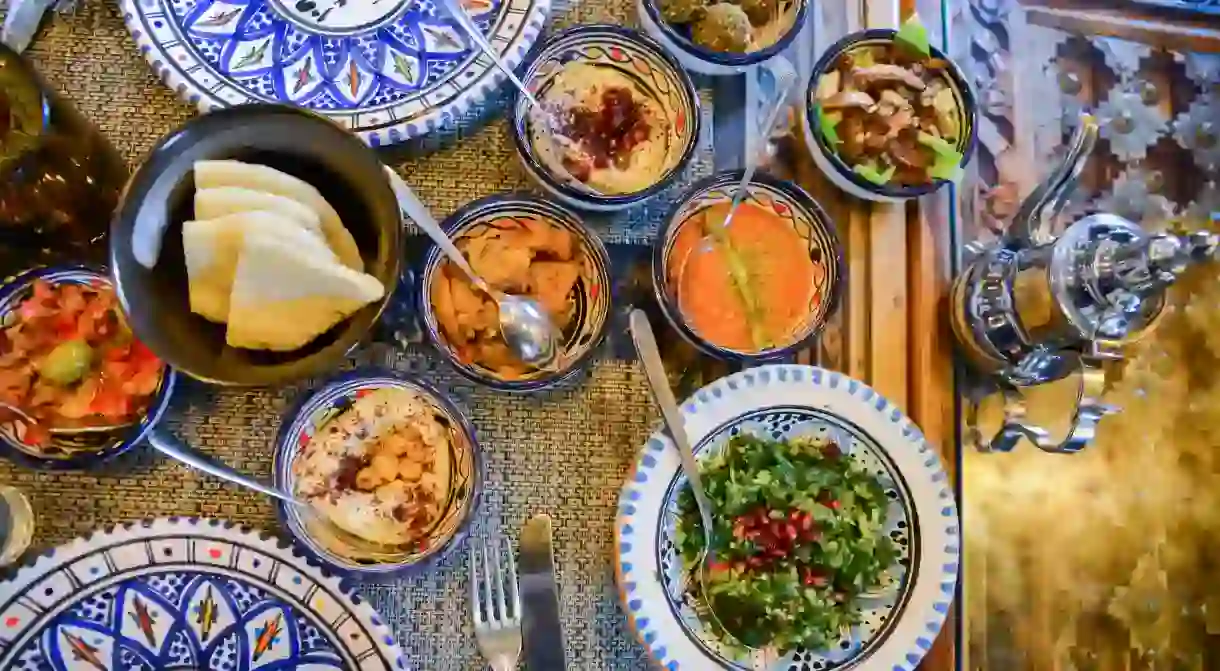 M5JNAM Middle eastern or arabic dishes and assorted meze, concrete rustic background. Meat kebab, falafel, baba ghanoush, muhammara, hummus, sambusak, etc