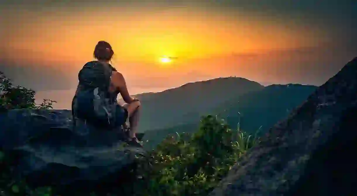 A backpacker enjoys the view of Da Nang Bay and the Ba Na mountains