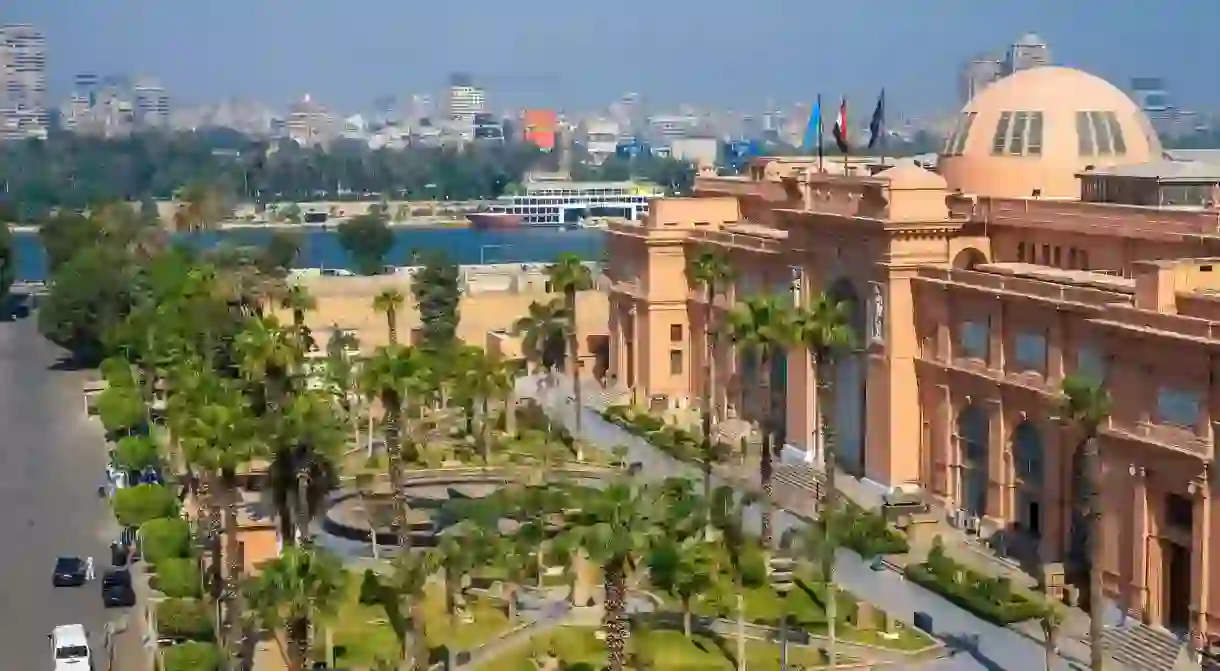 An aerial view of the facade of the Egyptian Museum in Cairo, with the Nile River in the background