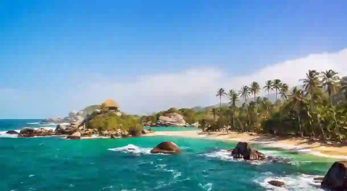 Palm trees and blue Caribbean water on the beach of San Juan del Guia in Tayrona National Park in Colombia