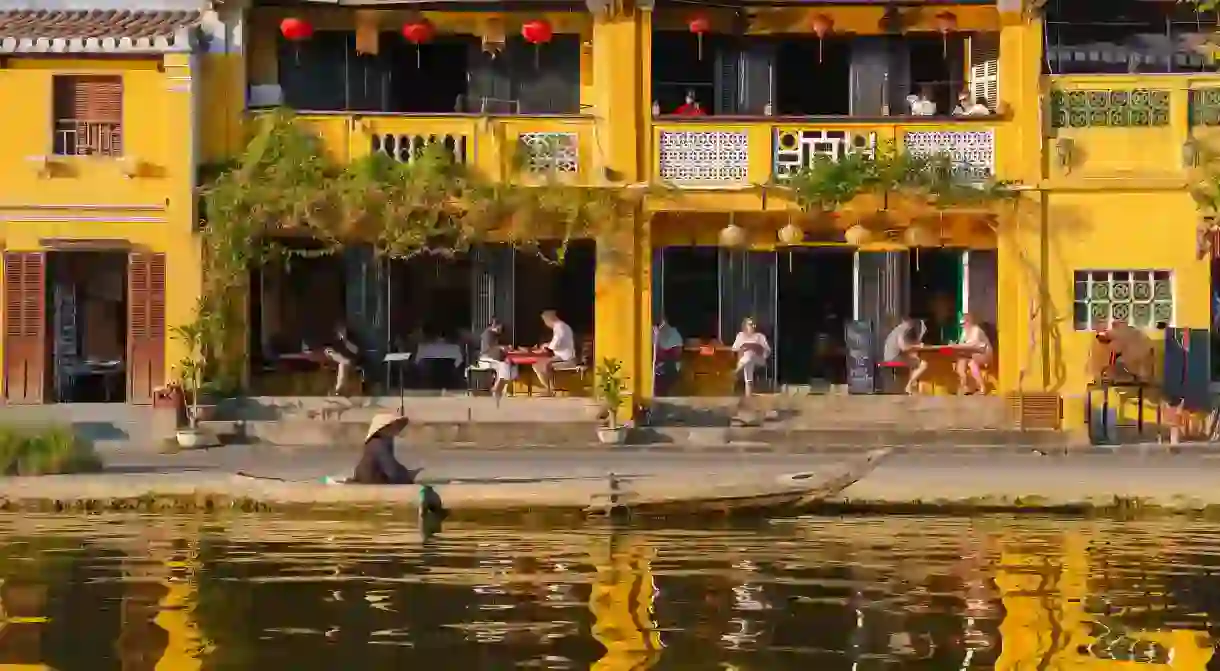 M8RNN9 Hoi An tourists Vietnam, at sunset along the Thu Bon river in the Old Town quarter of Hoi An tourists relax in a waterfront cafe bar, Vietnam.