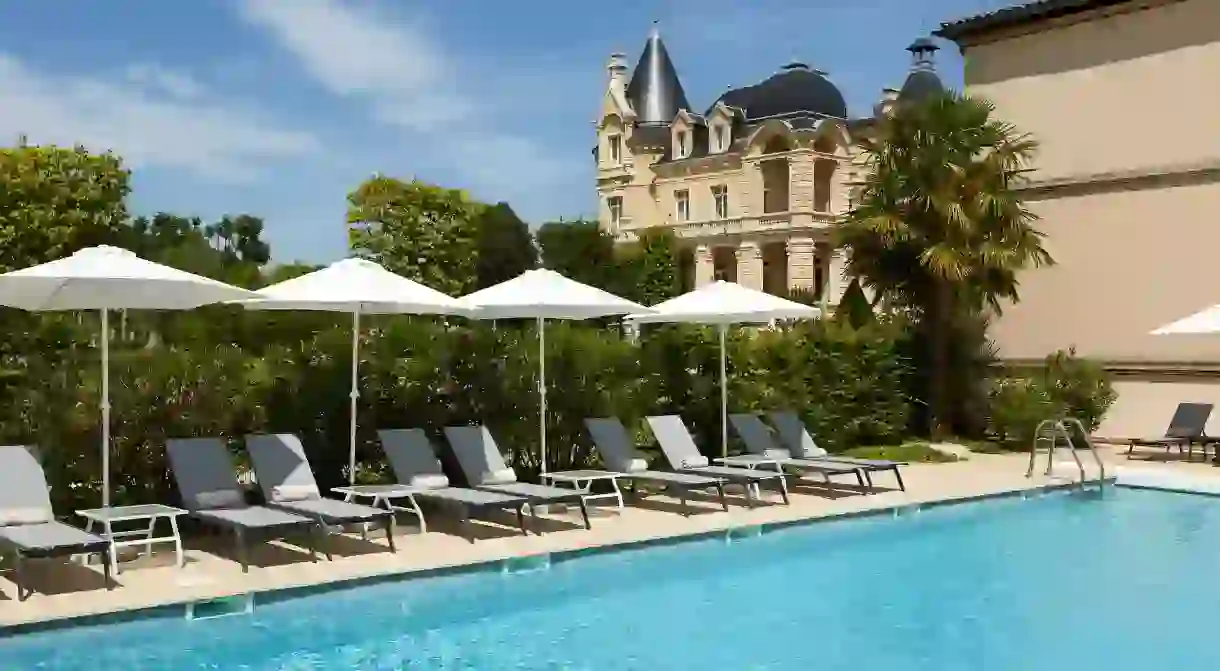 Relax poolside at the Château Hôtel Le Grand Barrail near Bordeaux, France