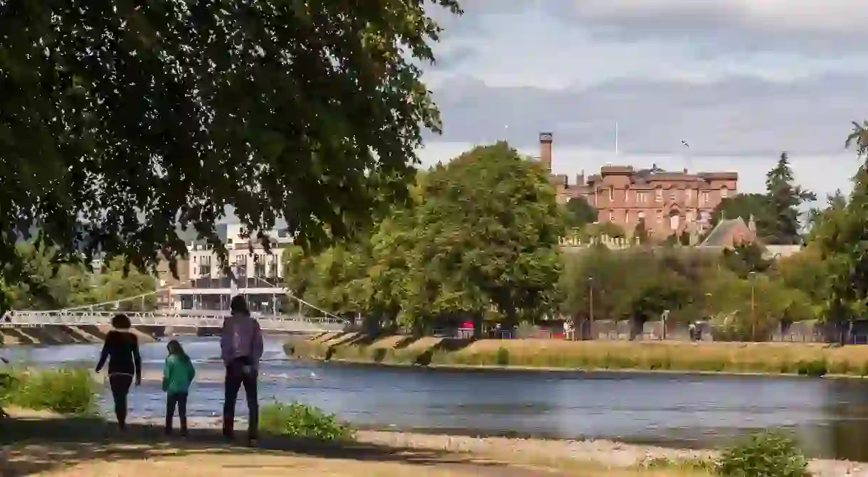 People walking on the path beside the River Ness in the city of Inverness