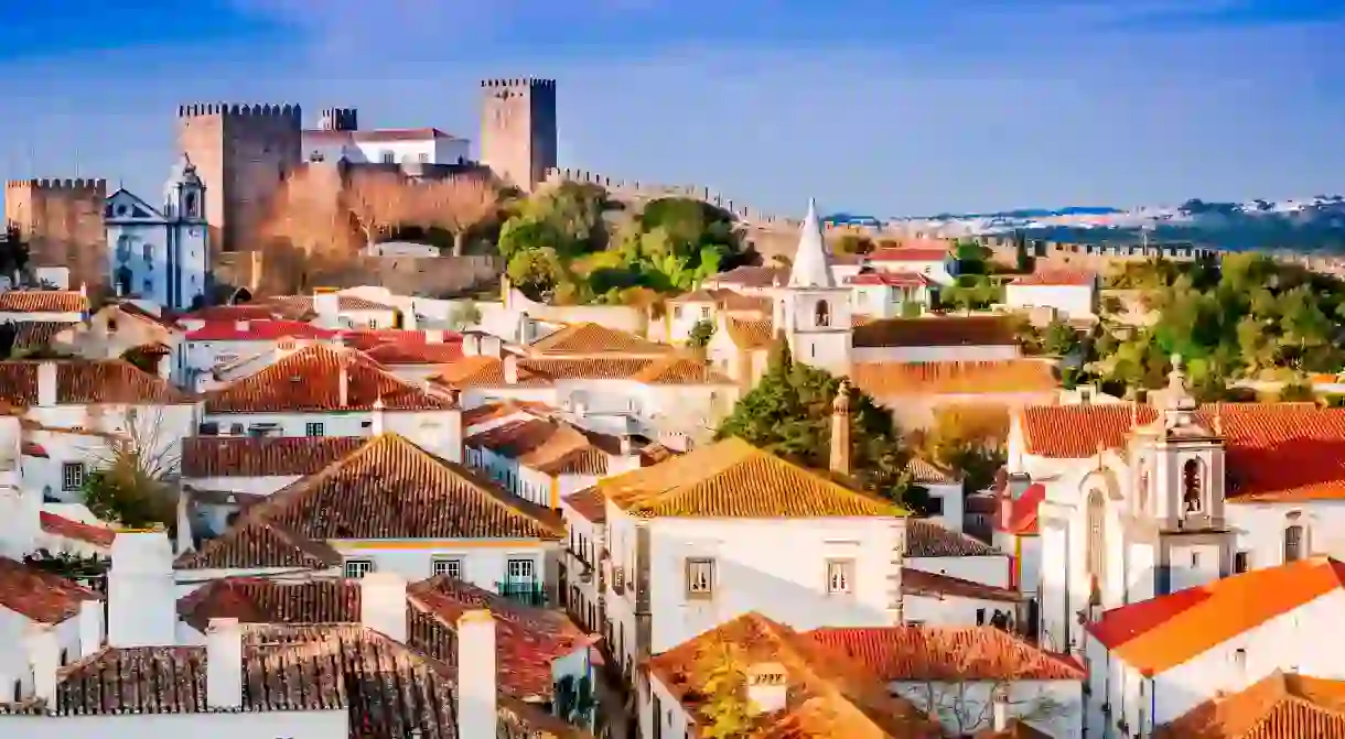 Red roofs and a Medieval castle make up the skyline of Óbidos, Portugal