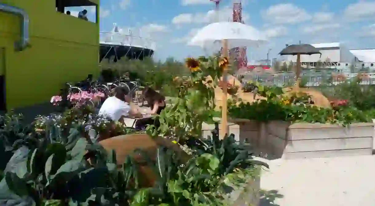 C76F5K A couple sitting eating at outdoor cafe at the View Tube area with a view of the Olympic Stadium in Stratford, Newham East London UK KATHY DEWITT. Image shot 07/2011. Exact date unknown.