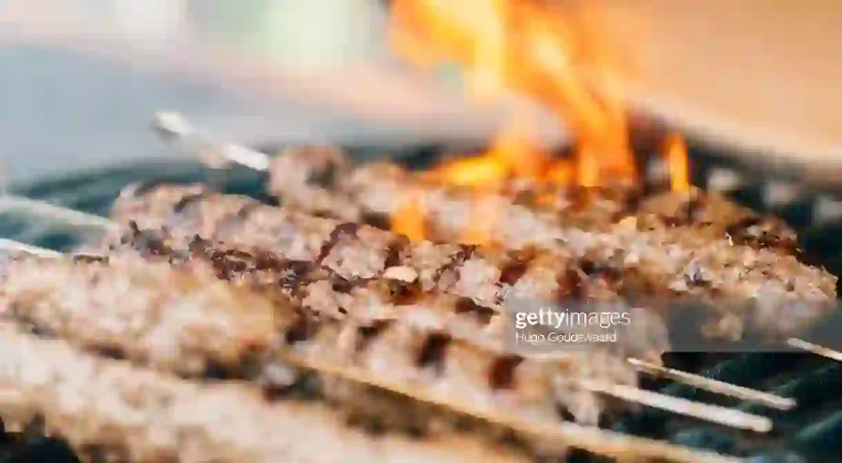 Lamb kebab skewers on a ceramic bbq at a summer garden party. Close-up.