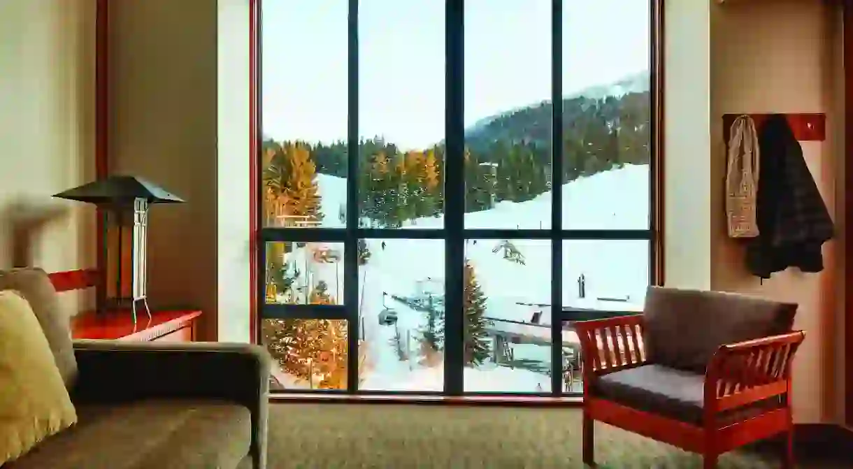 Relax with views of wintry forests and snow-capped peaks from a luxe room in Whistler