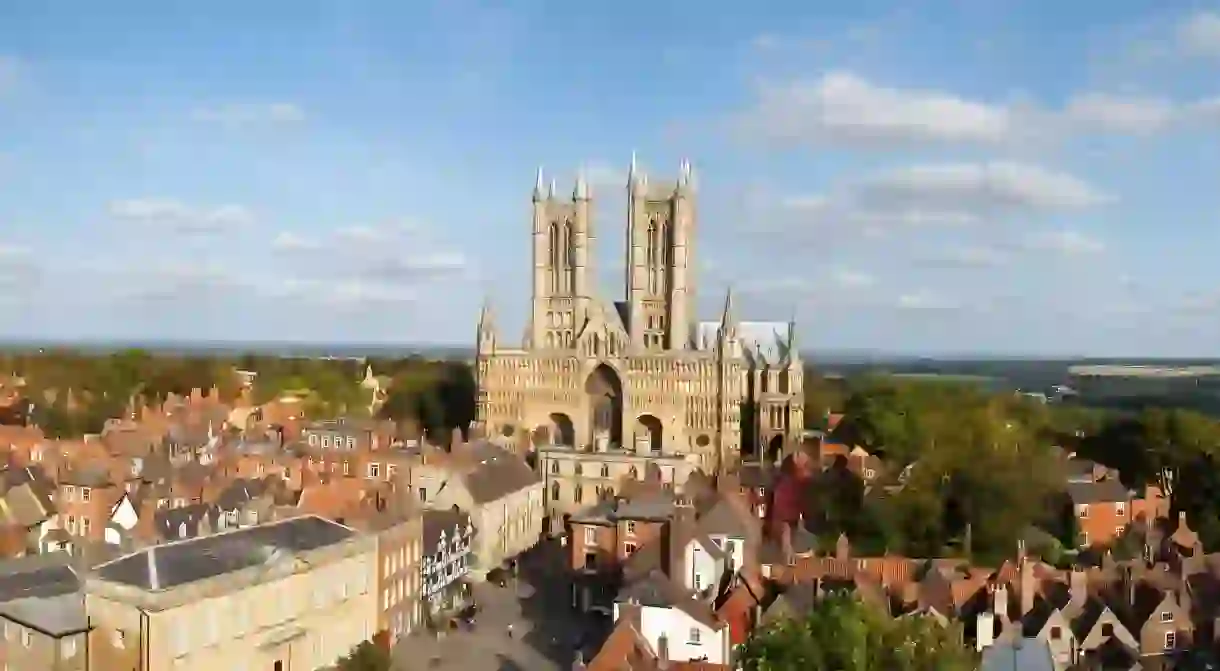 The Medieval Lincoln Cathedral stands out among the verdant landscape and buildings in Lincoln