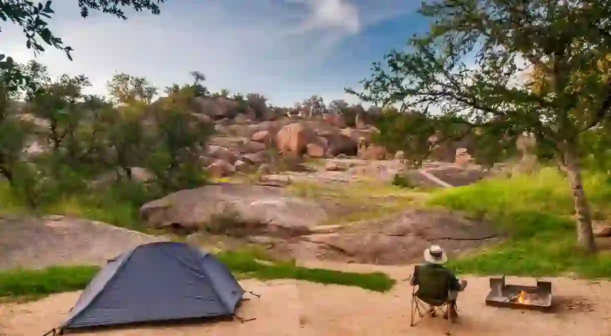 Camper at campsite in Enchanted Rock State Natural Area in Hill Country near Fredericksburg, Texas, USA