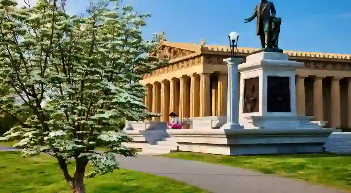 C3DY2N Young Woman relaxing below statue of JW Thomas and Parthenon replica in Centennial Park, Nashville Tennessee USA. Image shot 2011. Exact date unknown.