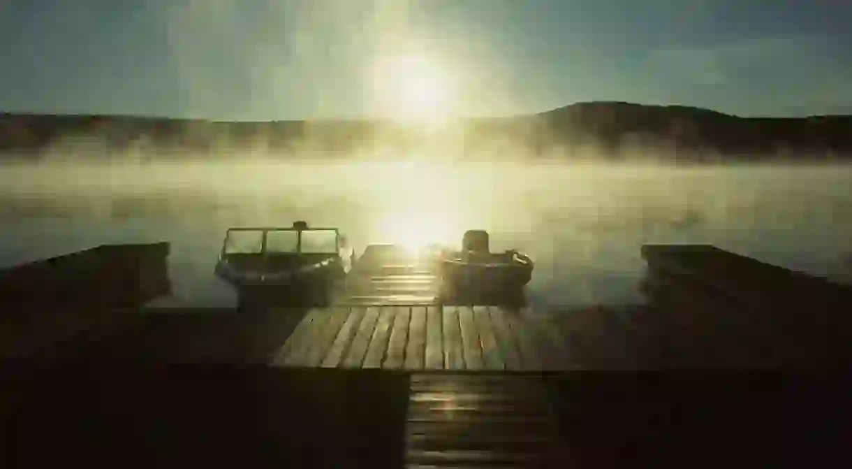 Boats docked in morning mist,Lake Groton, Stillwater Park, Vermont, USA