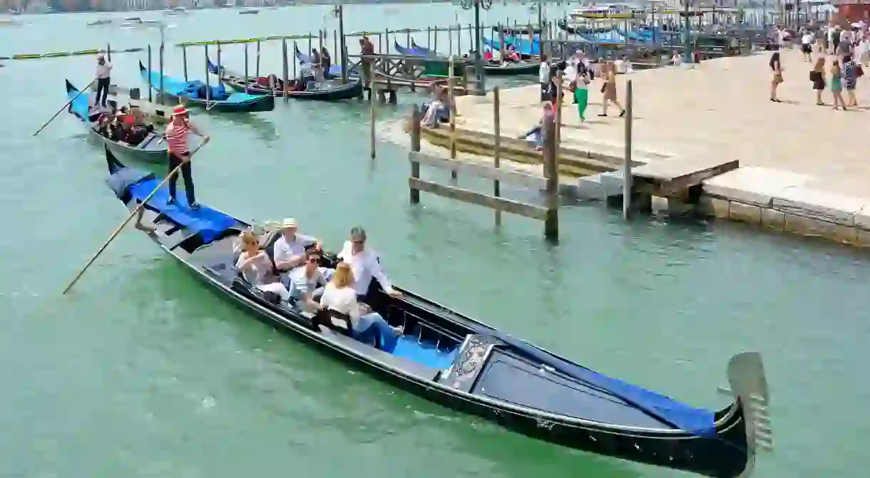 FPEDXW Venice gondola Italy leaving moorings with sightseeing passengers for tour around the cities canals