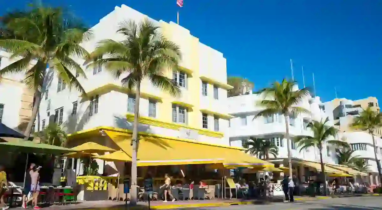 MIAMI - CIRCA SEPTEMBER, 2018: Brightly colored awnings shade the morning sun from visitors gathered for breakfast in sidewalk cafes on Ocean Drive