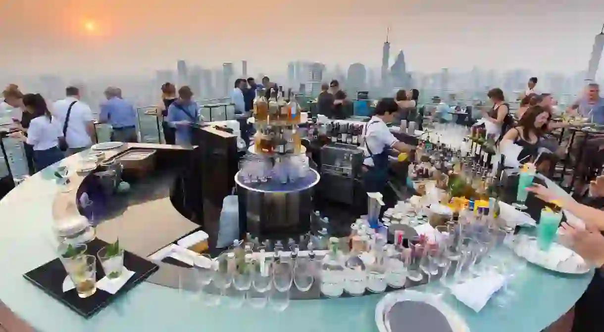 People drinking and enjoying the sunset at the Octave rooftop bar of the Marriott tower hotel in the Thong Lor