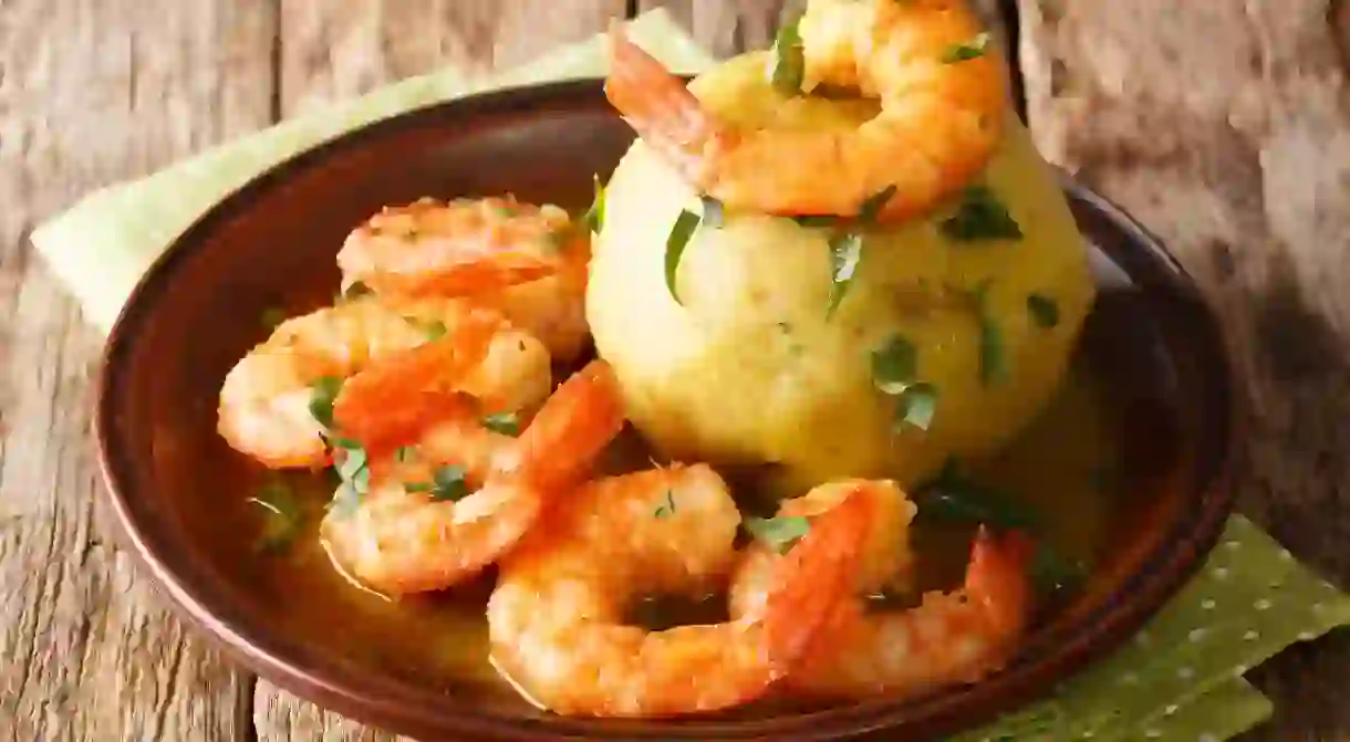 RK0GTB Latino american main course mofongo with shrimps and broth close-up on a plate on the table. horizontal