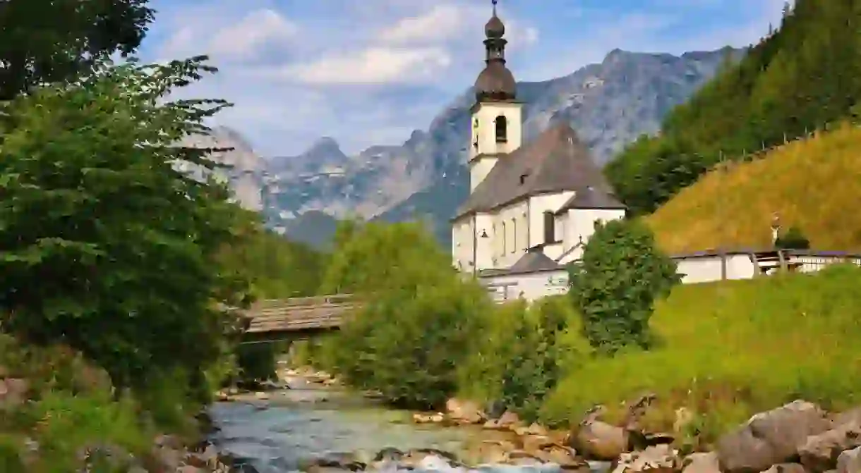 Church of St. Sebastian in a landscape with a mountain stream and Alps in Ramsau bei Berchtesgaden in Berchtesgadener Land in Bavaria, Germany.