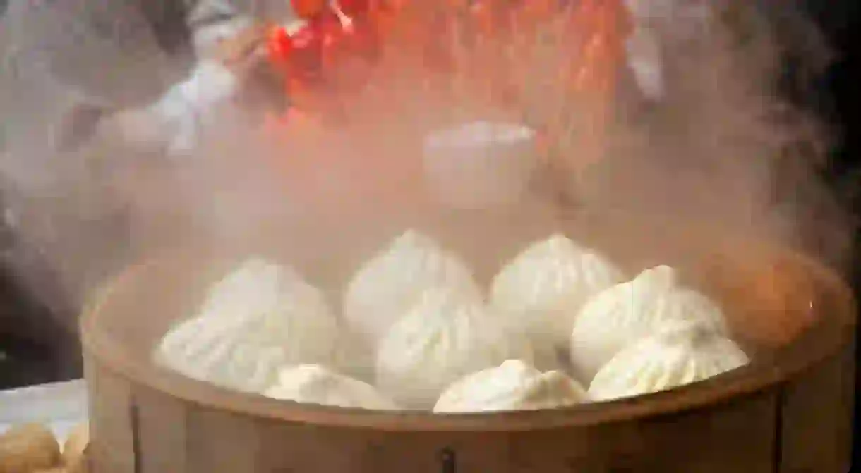 2ARY464 Asian dumplings, called dim sum, cooking in a wooden steamer in Yokohama Japans Chinatown near Tokyo.