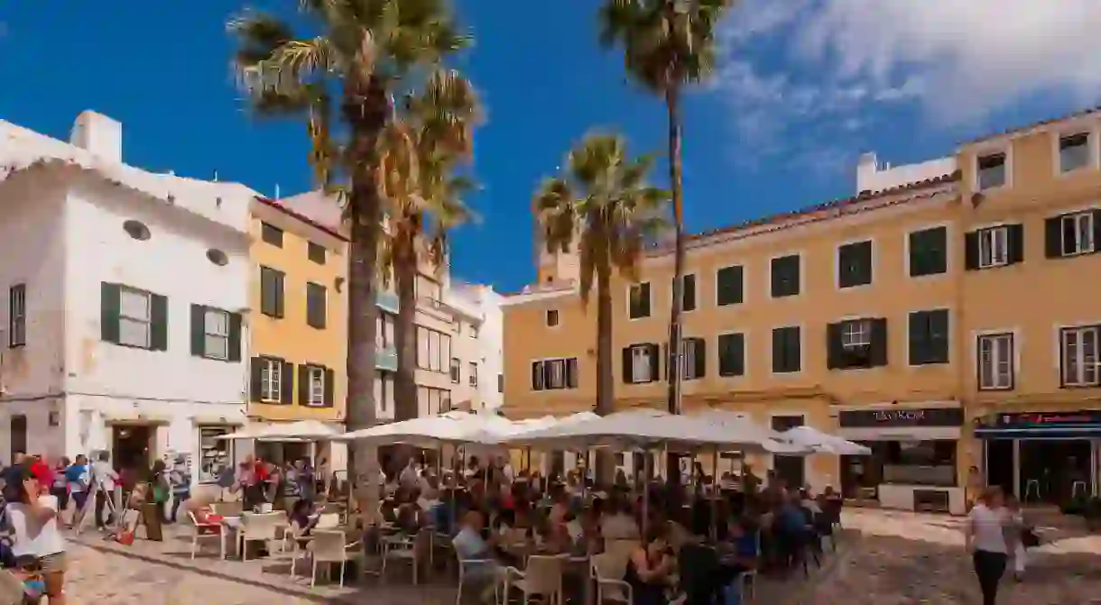 People sitting outside at a bar cafe in Mahon , Menorca , Balearic Islands , Spain