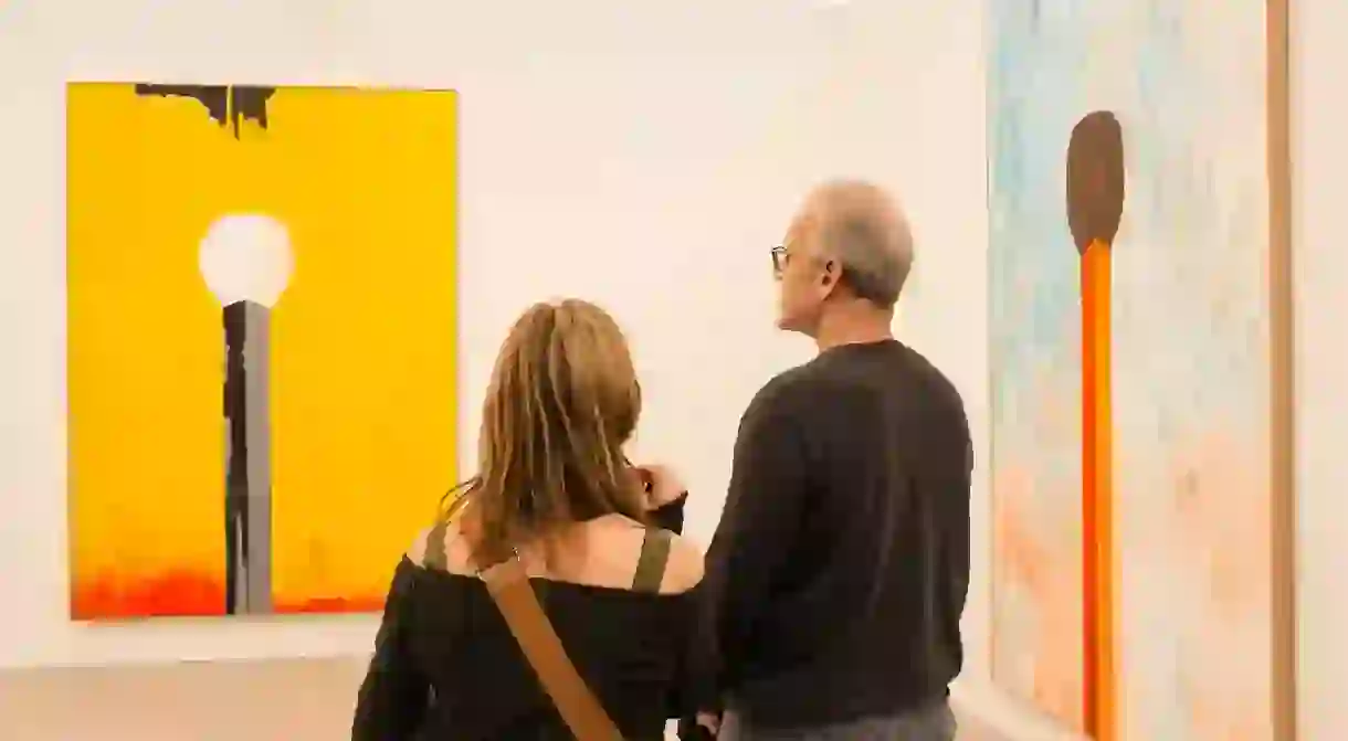 Spectators amid large paintings of matches by Harold Ancart in the David Zwirner Gallery