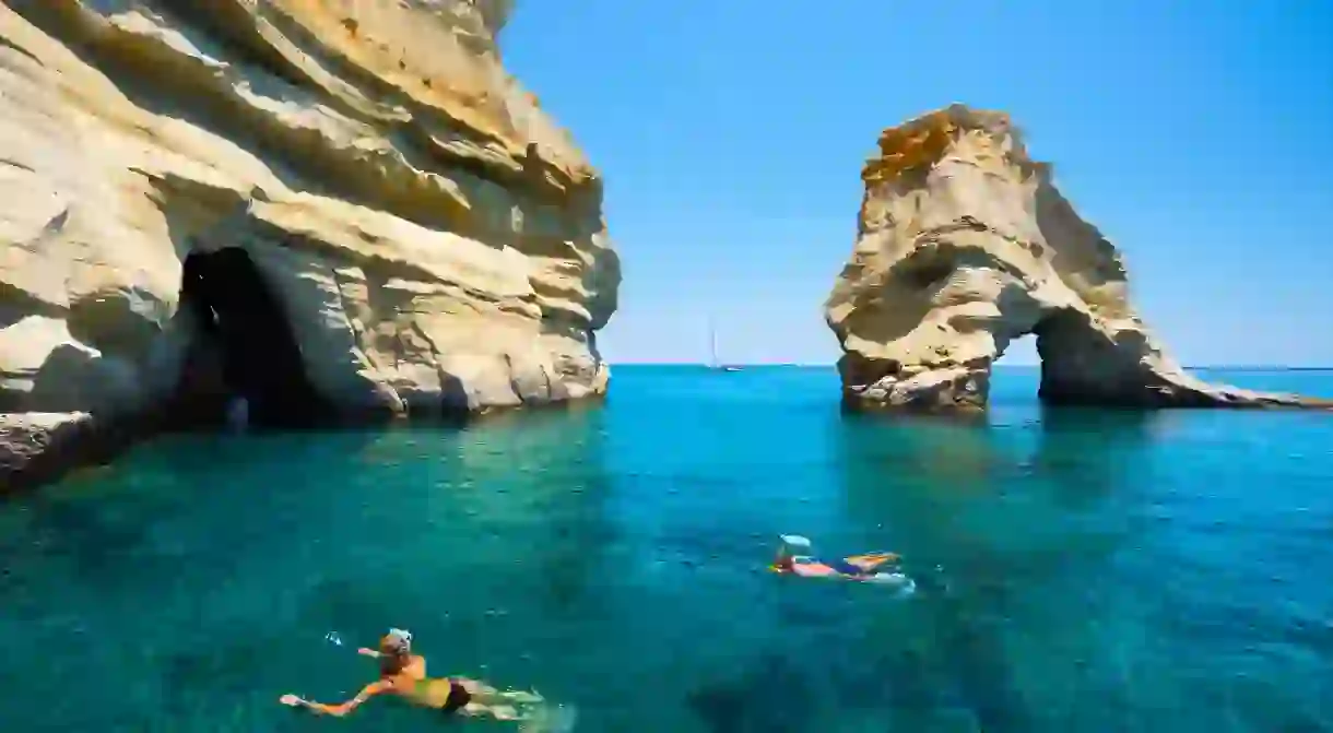 Snorkellers amongst rock formations with crystal clear water, Kleftiko Greek Islands